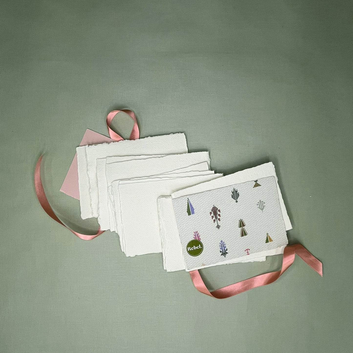 Set of white cards with printed designs on a green background