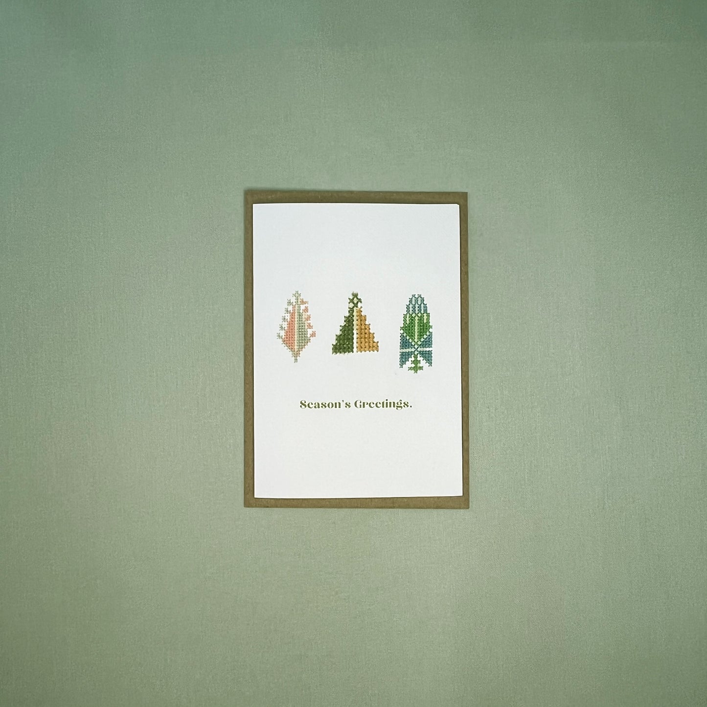 Trio of Tatreez embroidery on A6 Season's Greeting card on brown envelope on pistachio linen background