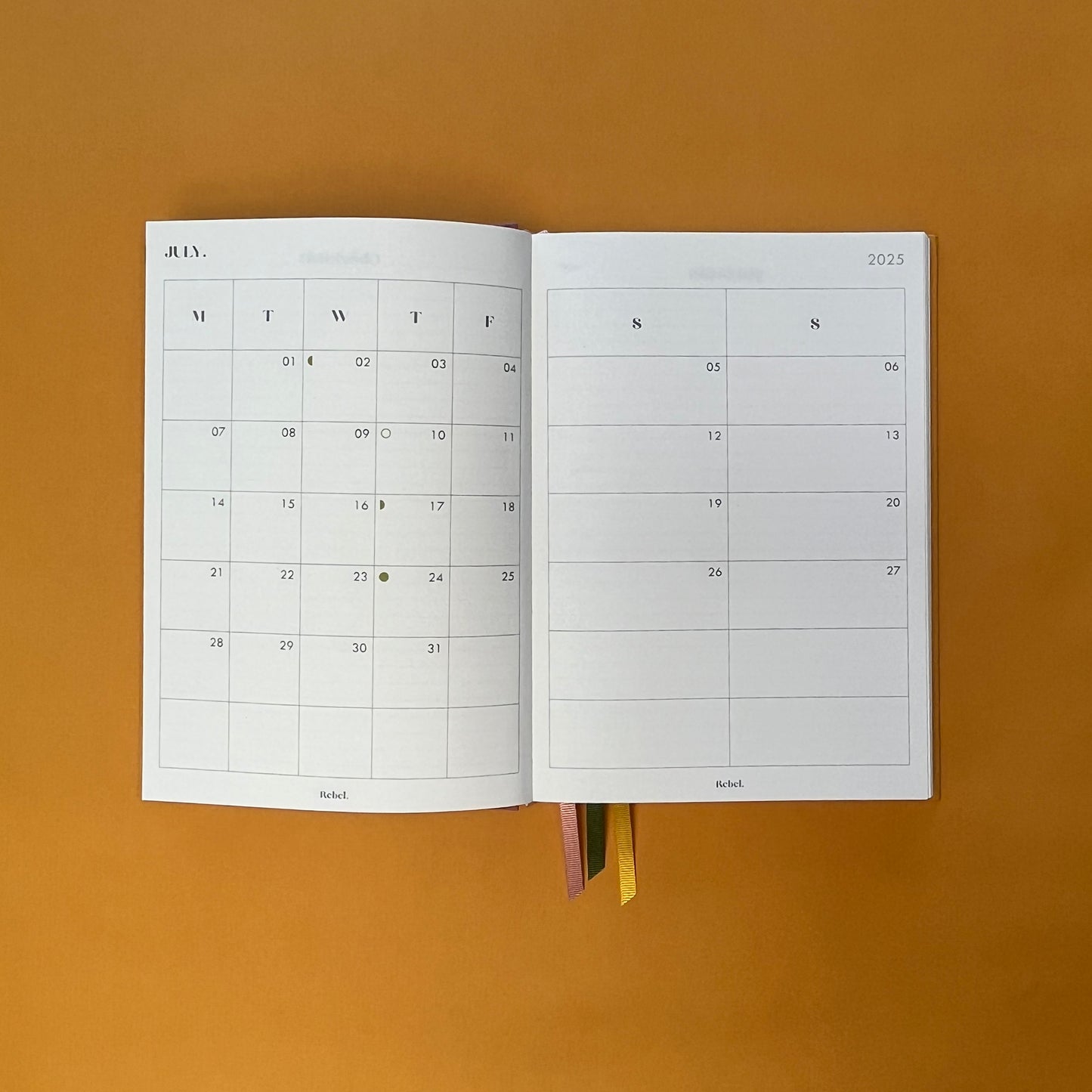 Planner spread of Rebel Stationery's Gold Seasonal notebook (yellow cover with pink linen spine) on a yellow background