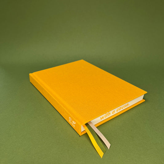 Rebel Stationery's Signature A5 diary in yellow bookcloth, on a green backround