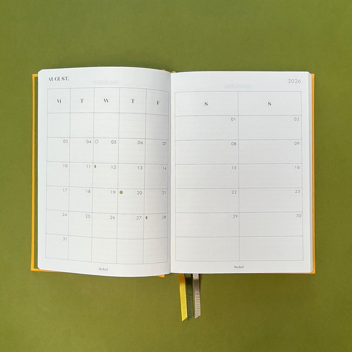 Planner spread of Rebel Stationery's Signature A5 diary in yellow bookcloth, on a green backround
