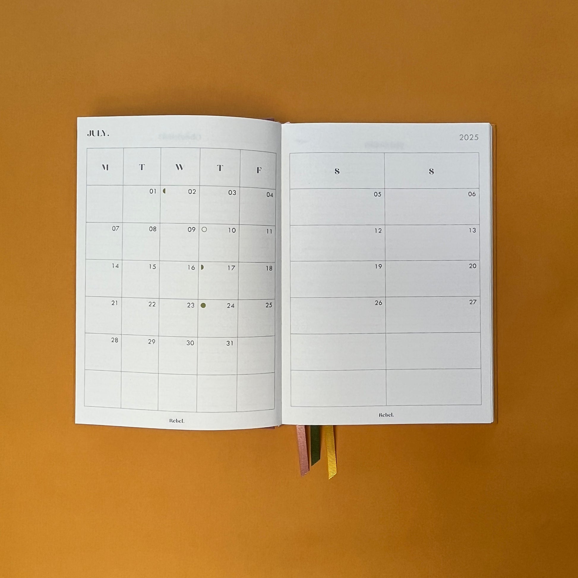 Planner spread of Rebel Stationery's Gold Seasonal notebook (yellow cover with pink linen spine) on a yellow background