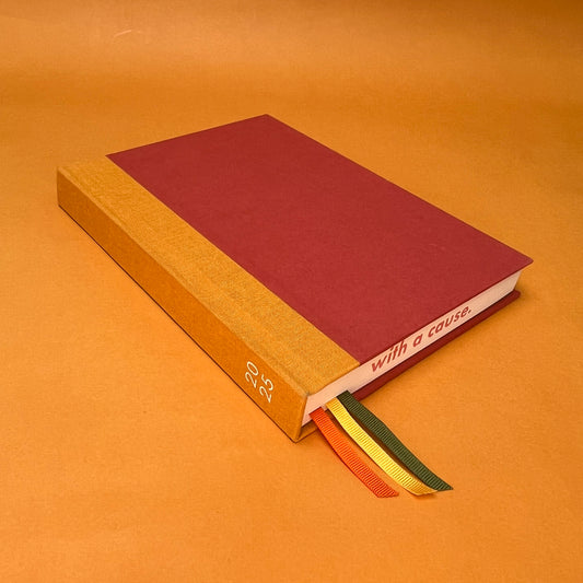Rebel Stationery's Seasonal Orange 2025 diary, on a yellow background
