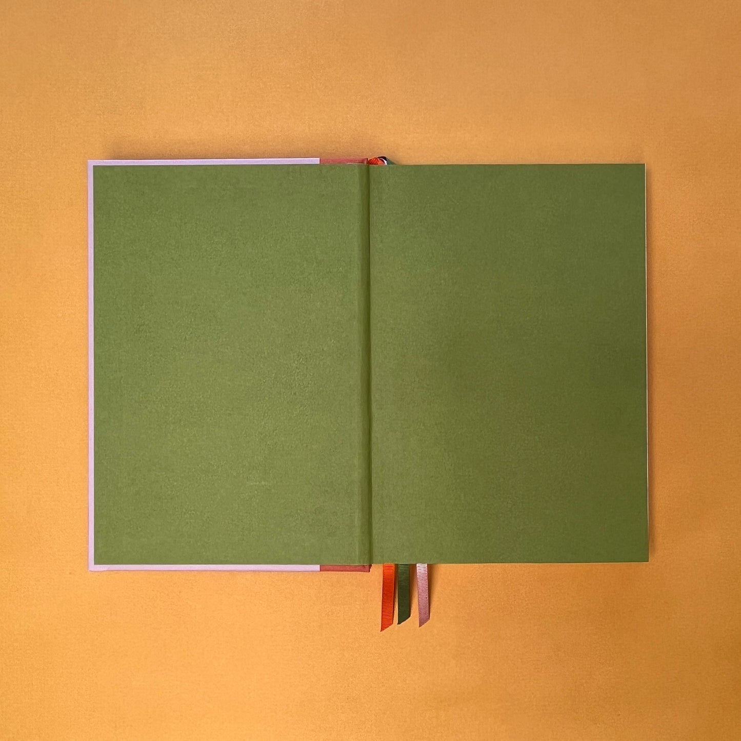 Endpaper of Rebel Stationery's Seasonal Rose notebook, a pink A5 with orange-red linen spine, on a yellow background