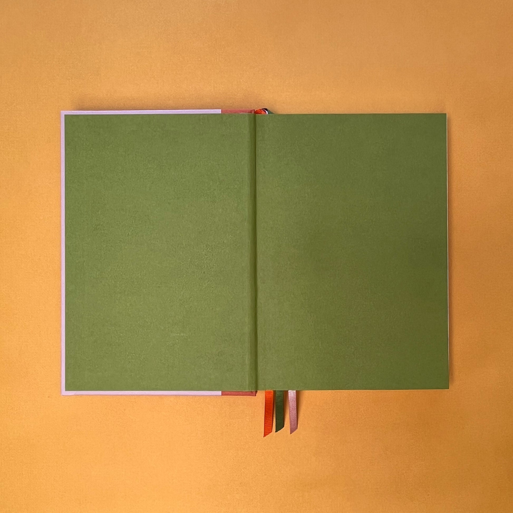 Endpaper of Rebel Stationery's Seasonal Rose notebook, a pink A5 with orange-red linen spine, on a yellow background