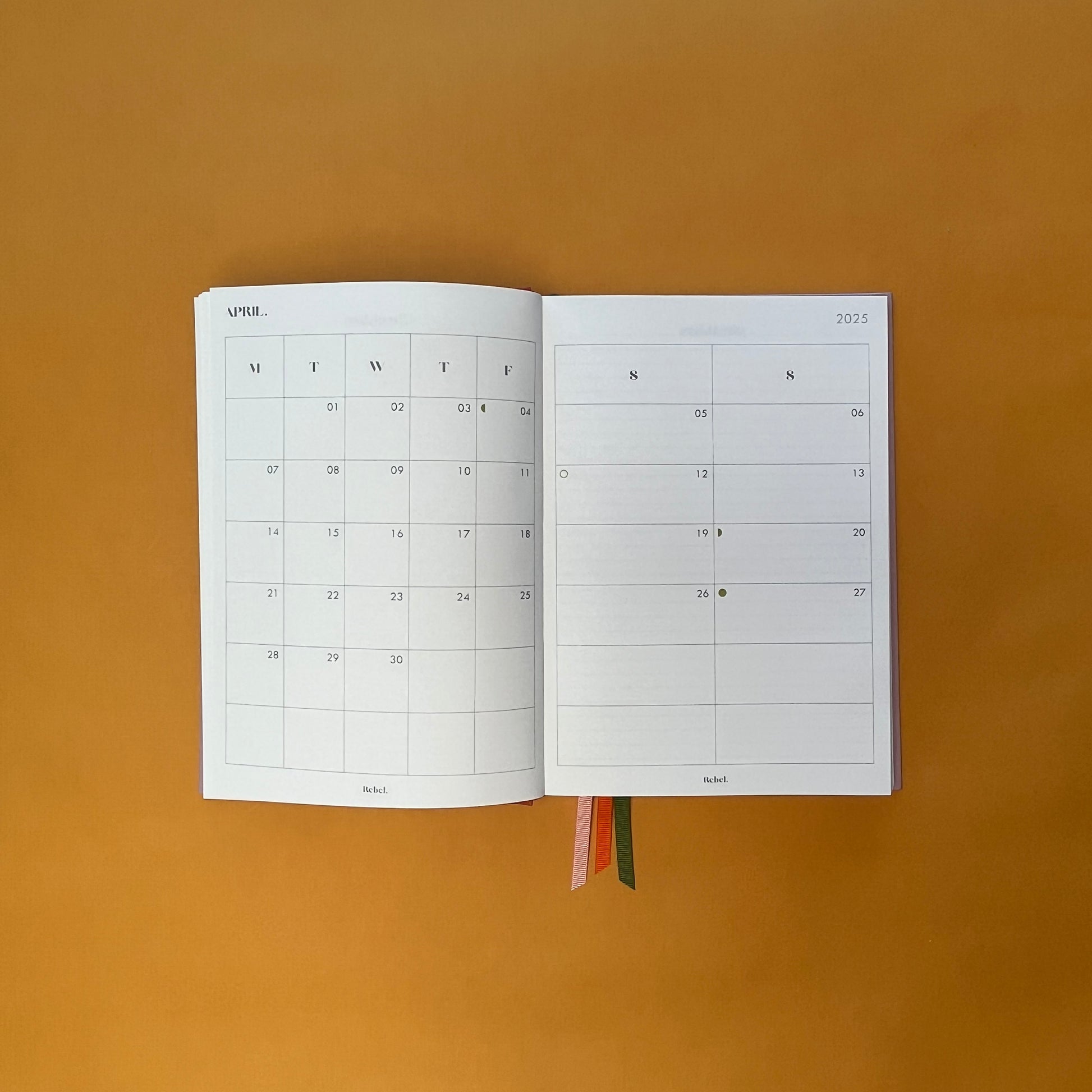 Planner spread of Rebel Stationery's Seasonal Rose notebook, a pink A5 with orange-red linen spine, on a yellow background
