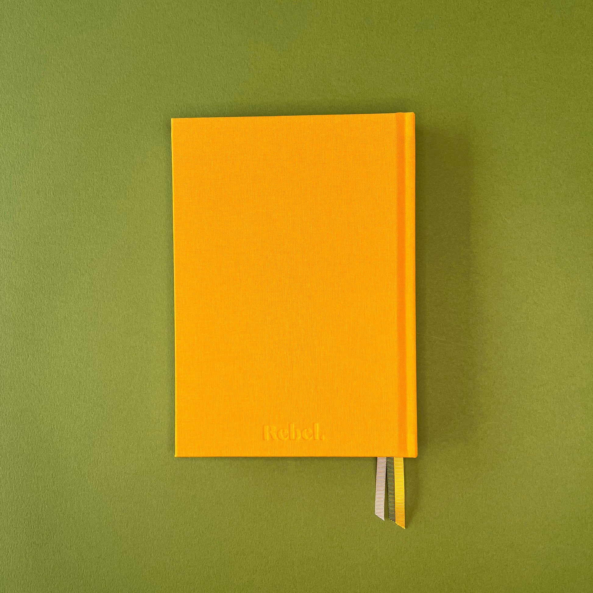 Bak=ck cover of Rebel Stationery's Signature A5 notebook in yellow bookcloth, on a green background