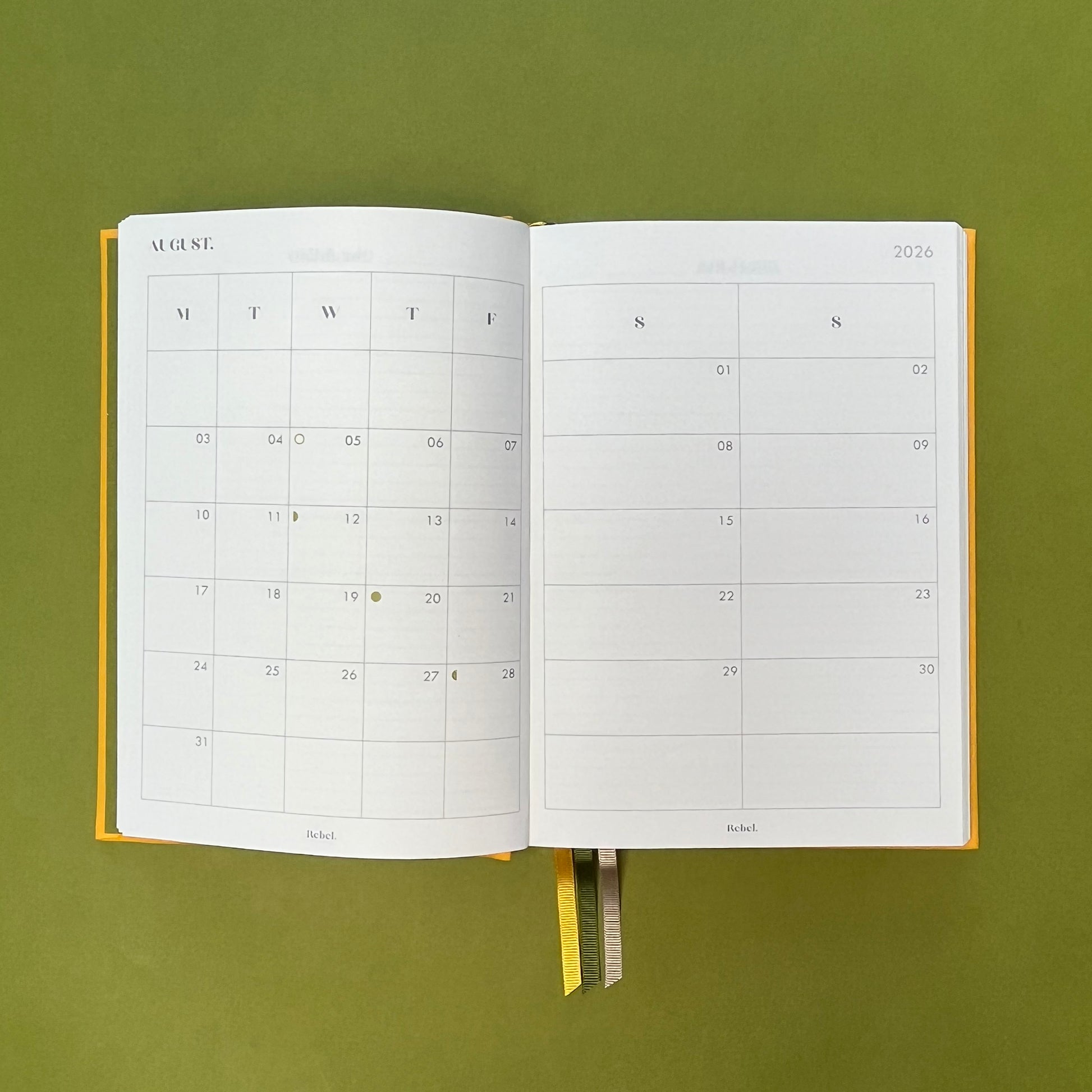 Planner spread of Rebel Stationery's Signature A5 diary in yellow bookcloth, on a green backround
