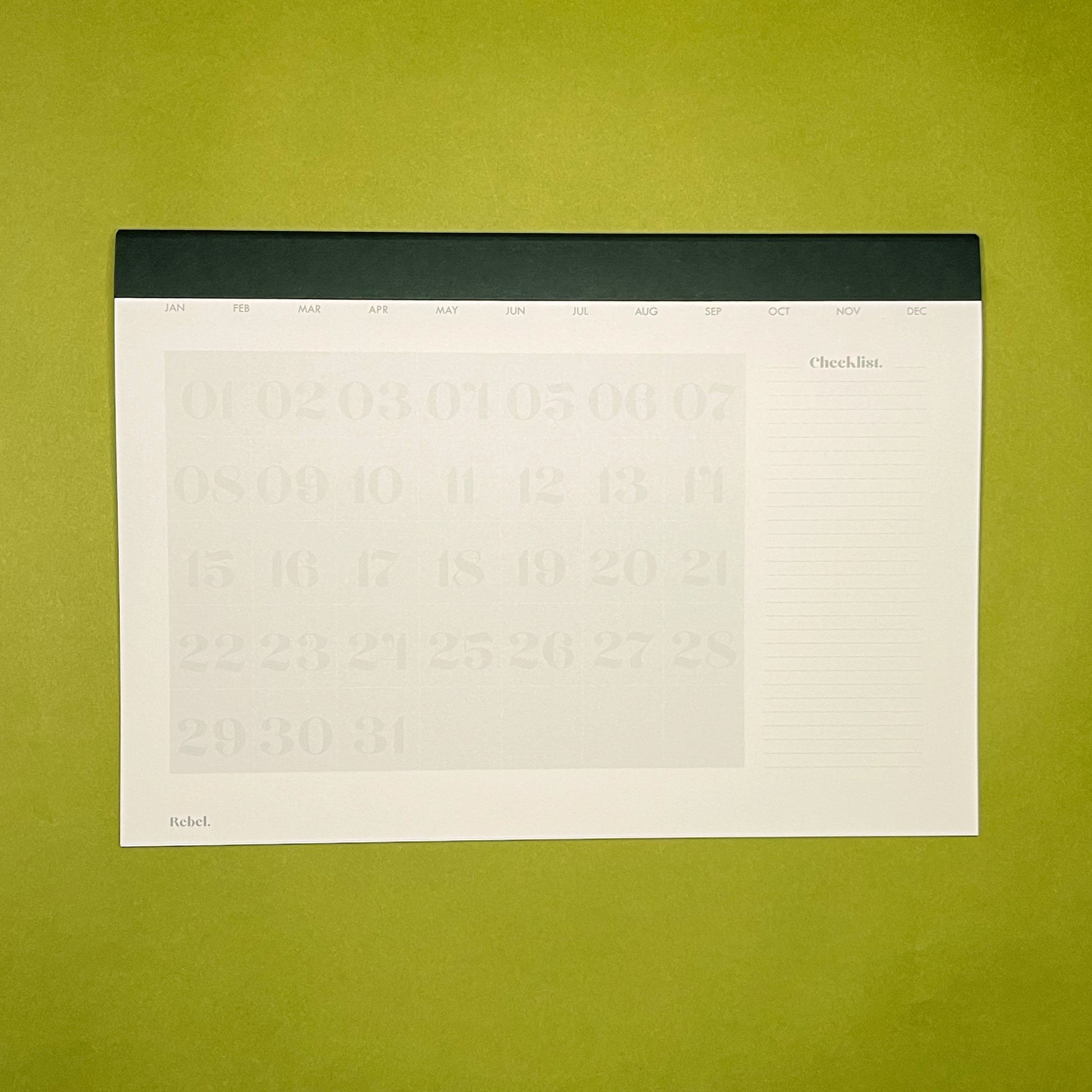 Inside spread of Rebel Stationery's A4 Monthly Desk Planner in Ink on green background