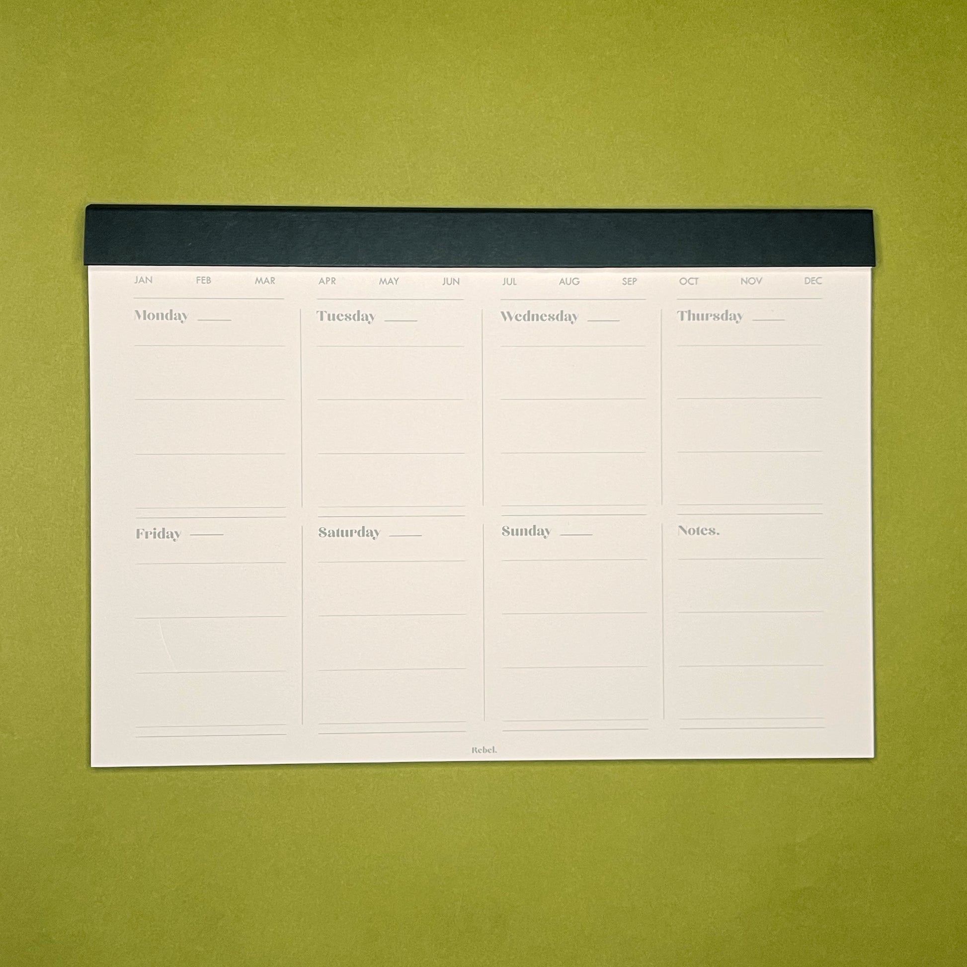 Inside spread of Rebel Stationery's A4 Weekly Desk Planner in Ink on green background