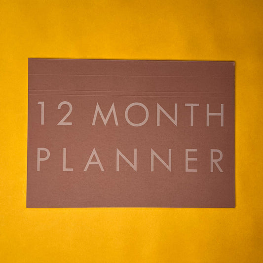 Pink desk planner with printed text on yellow background