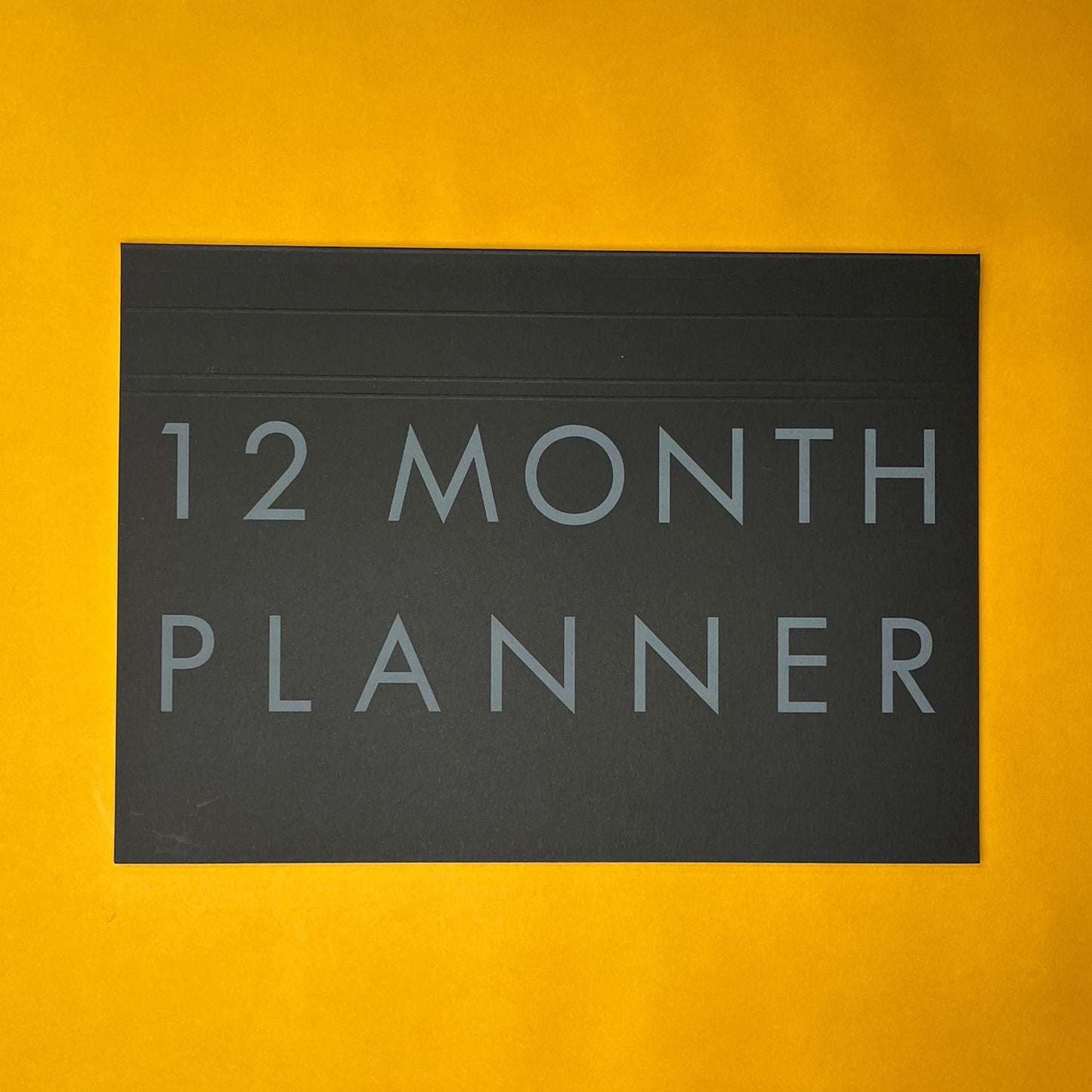 Black desk planner with printed text on yellow background