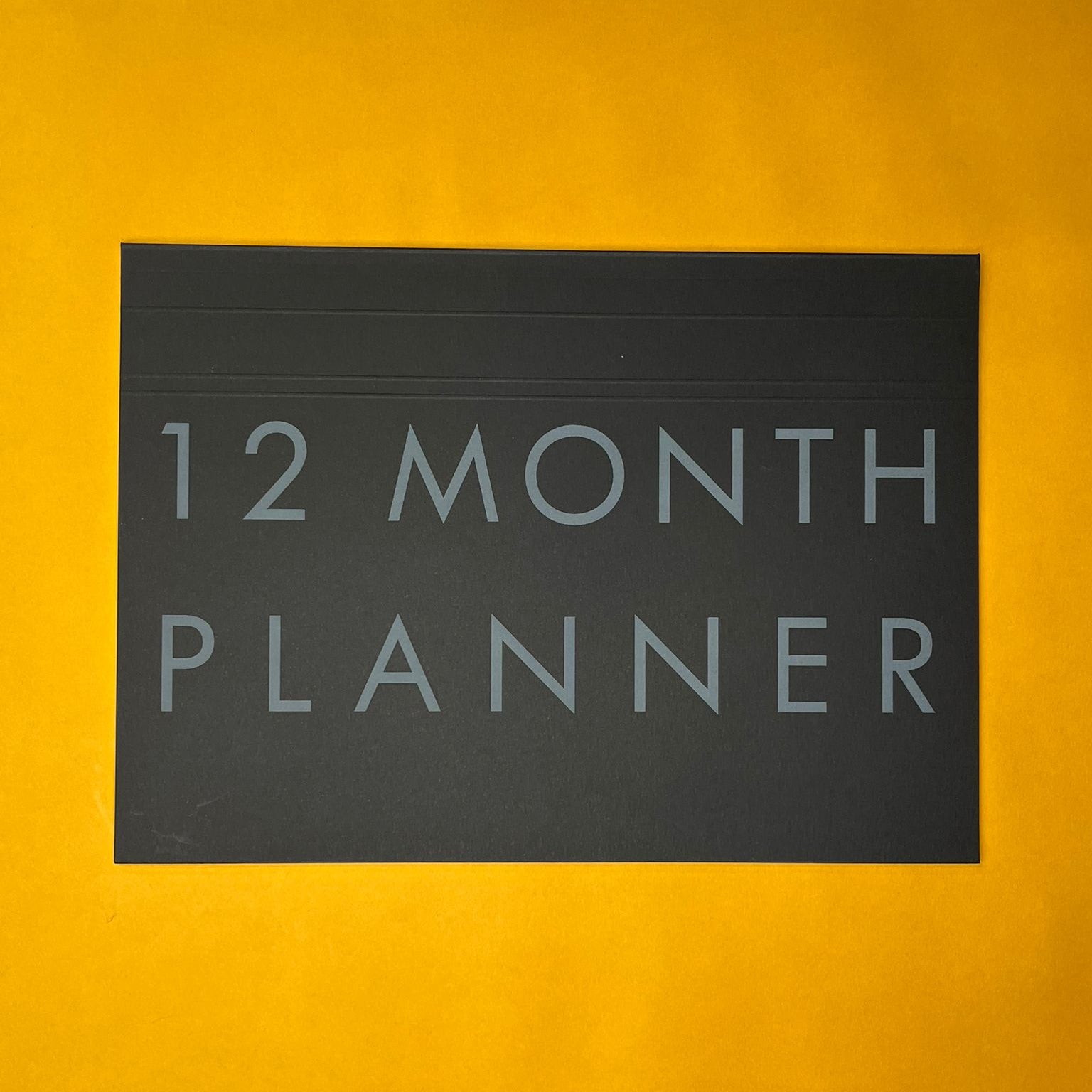 Black desk planner with printed text on yellow background