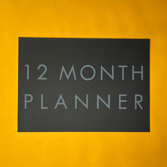 Black desk planner with printed text on yellow background