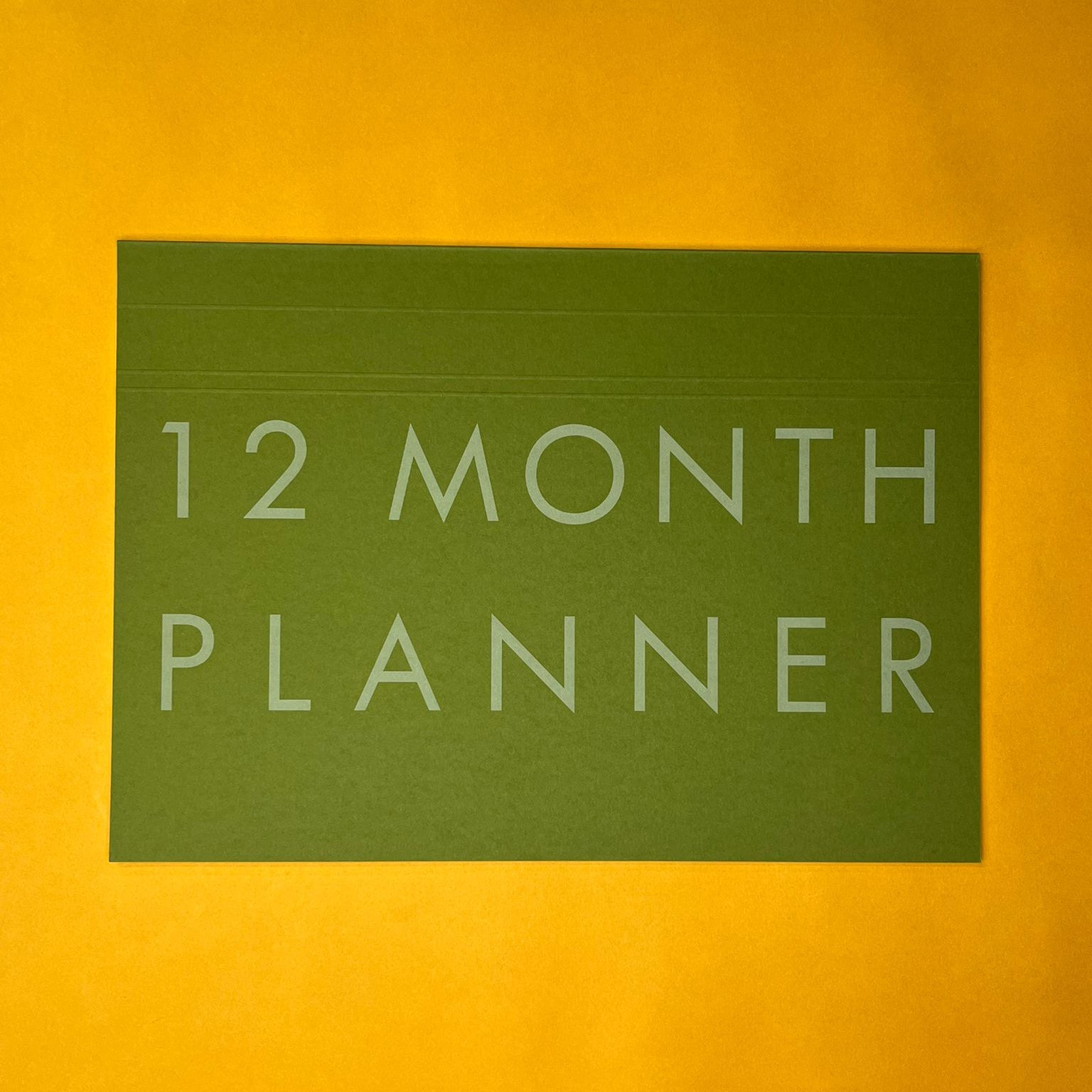 Green desk planner with printed text on yellow background