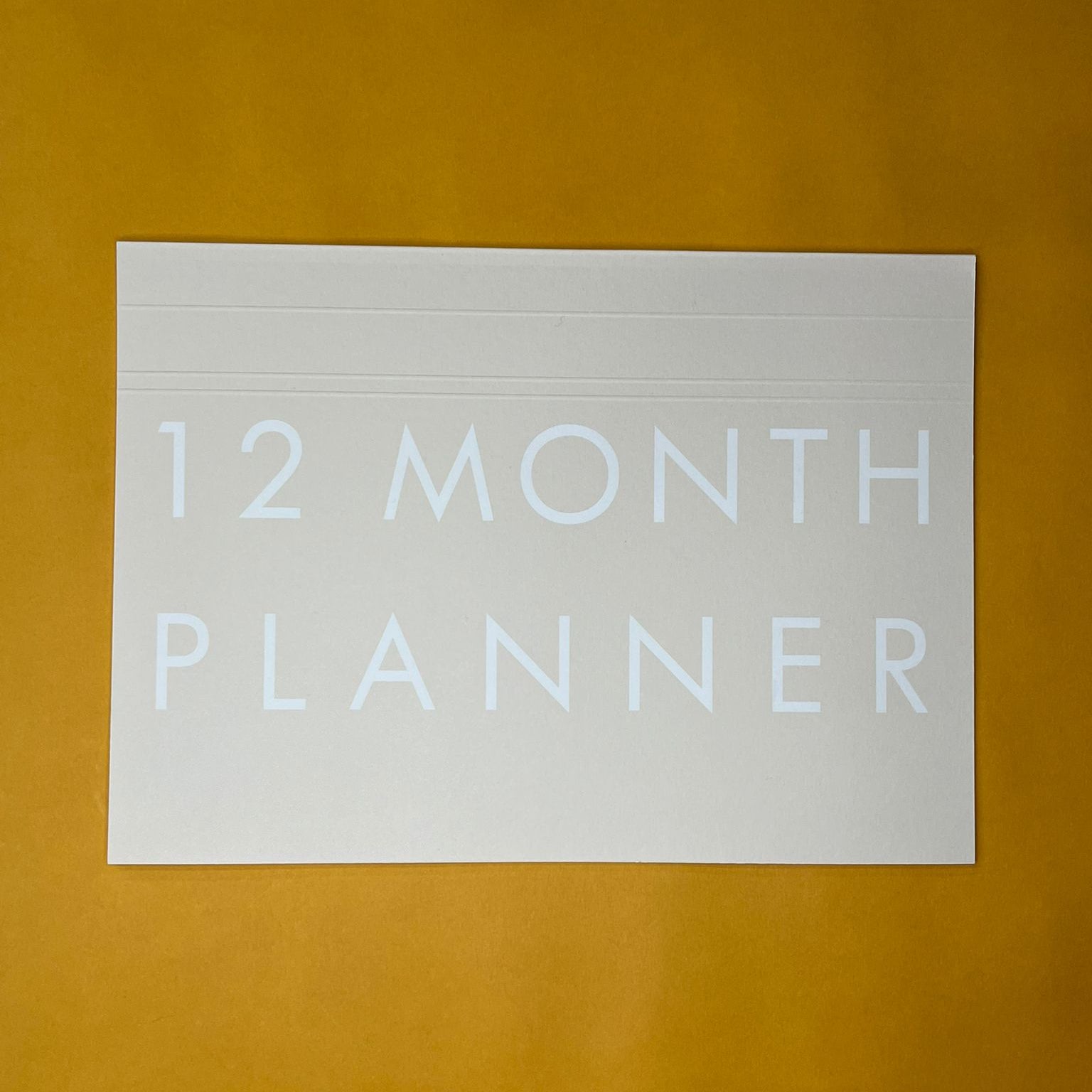 Beige desk planner with printed text on yellow background