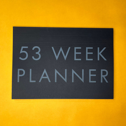 Black desk planner with printed text on yellow background