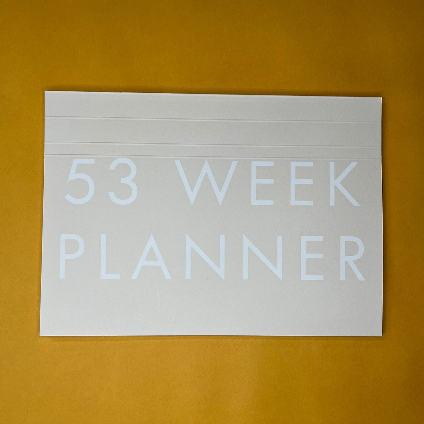 Beige desk planner with printed text on yellow background