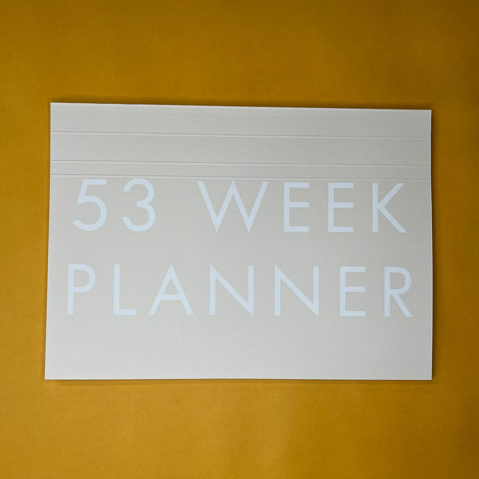 Beige desk planner with printed text on yellow background