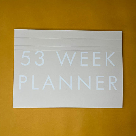 Beige desk planner with printed text on yellow background