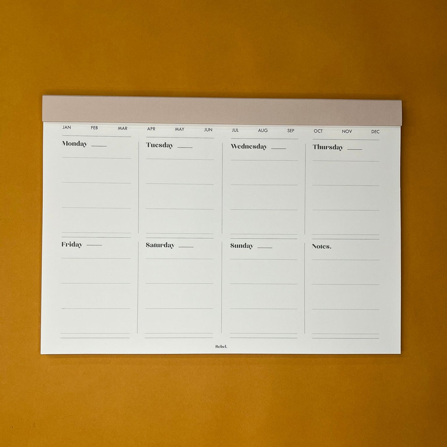 Beige desk planner with weekly layout on yellow background