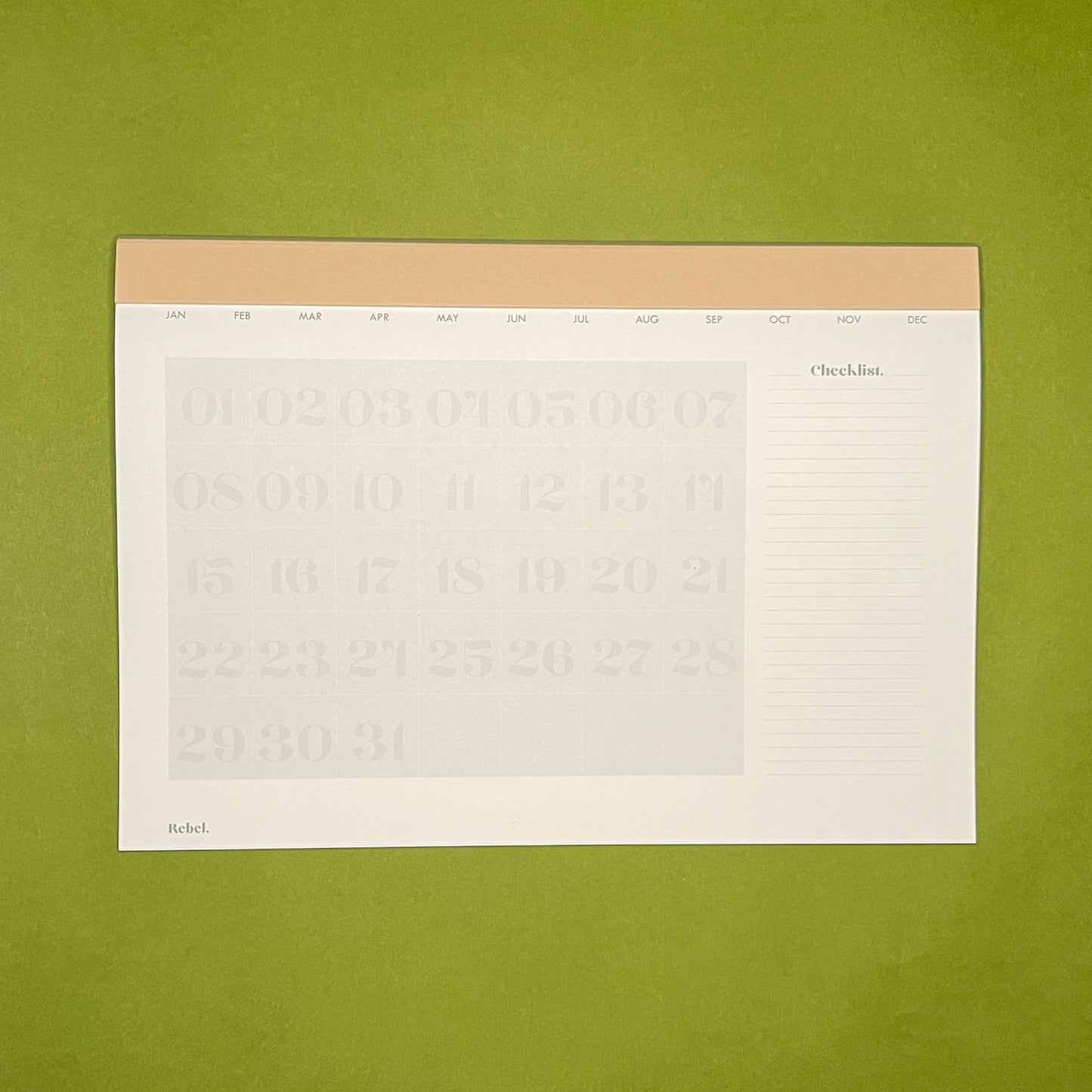 Inside spread of Rebel Stationery's Monthly Desk Planner in Stone on a green background